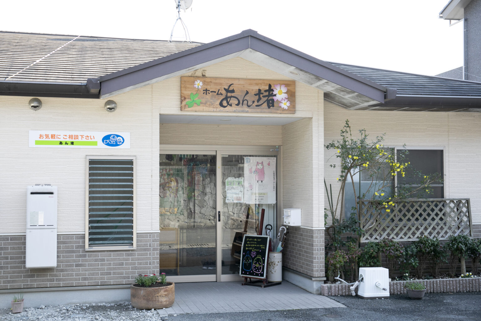 介護施設の玄関入口。看板に「ホームなんじゃく」と表記。